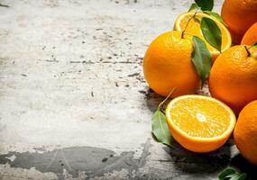 Fresh oranges with leaves. On rustic background. photo