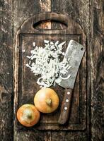 Fresh onion with old hatchet on a cutting board. photo