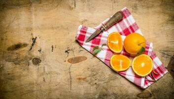 Fresh sliced oranges on the fabric. On wooden background. photo
