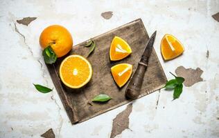 Sliced fresh oranges on the old board. photo