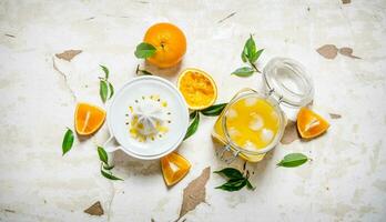 Fresh orange juice with ice, with slices of oranges and a juicer. photo