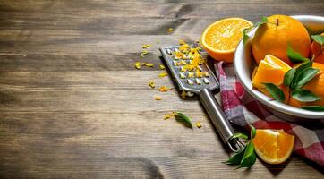 Cup with fresh oranges, zest and grater on fabric. photo