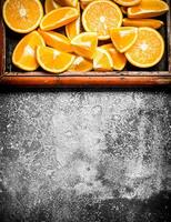 Pieces of ripe oranges in the old tray. photo