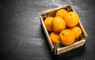 Fresco naranjas en un antiguo caja. foto