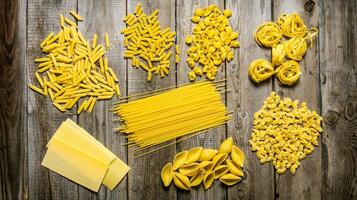 Different types of dry pasta . On wooden background. photo