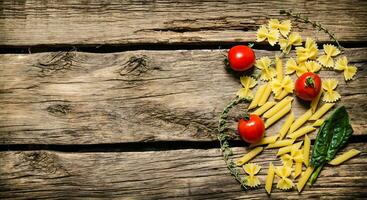 Dry pasta with cherry tomatoes and herb. photo