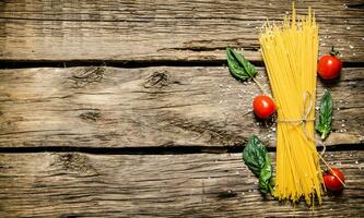 Dry spaghetti with tomatoes and herbs . photo