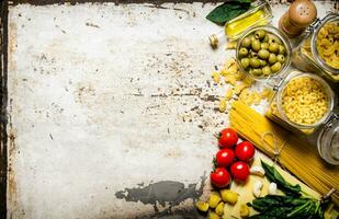 pasta antecedentes. un lote de diferente pasta, Olivos, Tomates, petróleo y hierbas. foto