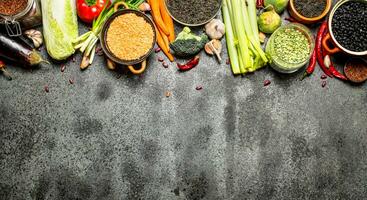 Organic Food. A variety of legumes with vegetables. On rustic background. photo