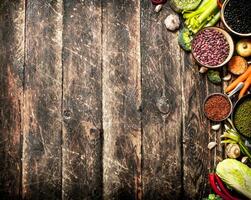 orgánico alimento. vegetales y varios frijol semillas en el antiguo de madera mesa. foto