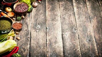 orgánico alimento. vegetales y varios frijol semillas en el antiguo de madera mesa. foto