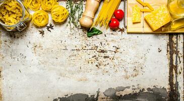 Pasta background. Dry pasta with vegetables, mushrooms, cheese and herbs. photo