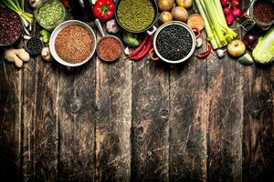 Organic Food. A variety of beans with fresh vegetables and spices. On the old wooden table. photo