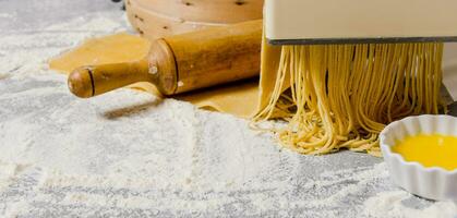 Cooking noodles. The pasta maker with a rolling pin and egg. photo