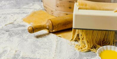 Cooking noodles. The pasta maker with a rolling pin and egg. photo