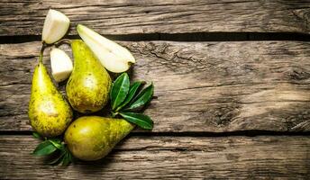 Fresh pears with leaves. On wooden background. photo
