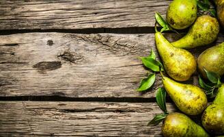 Fresh pears with leaves. On wooden background. photo