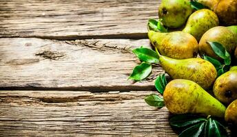 Fresh pears with leaves. On wooden background. photo