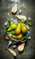 Pears in a saucepan with leaves and ice. photo