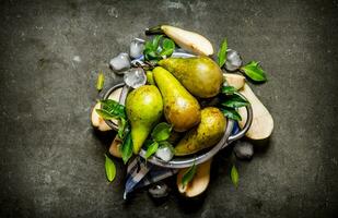 Pears in a saucepan with leaves and ice. photo