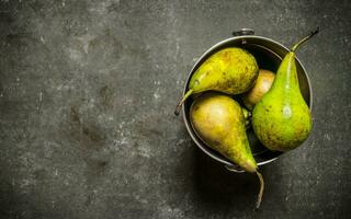 Fresh pears in the bucket. On  stone table. photo