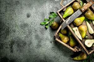 Ripe pears on a tray with an old knife. photo