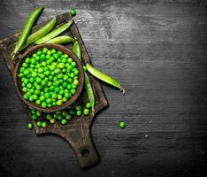 Fresh green peas in a bowl. On black chalkboard. photo