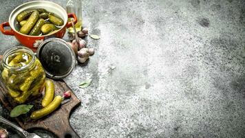 Marinated cucumbers in a bowl with spices and herbs. photo