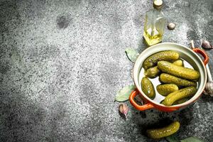 Marinated cucumbers in a bowl with spices and herbs. photo