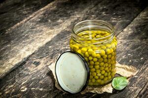 Pickled green peas in glass jar. photo