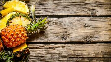 Fresh sliced pineapple with whole. On wooden background. photo