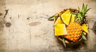 Fresh pineapple , chopped and whole in your shopping cart . photo