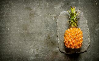 Fresh pineapple on a stone stand. On stone table. photo