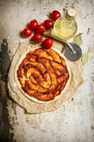 The rolled out pizza dough with tomatoes, tomato paste and olive oil. photo