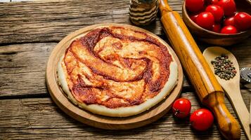 el arrollado fuera Pizza masa con tomate salsa, laminación alfiler y especias foto