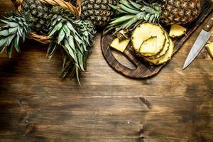 Sliced pineapple on a cutting Board with a knife. photo