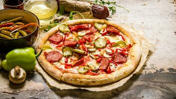 Tasty pizza with pepperoni and tomato sauce. photo