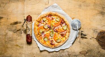 Tasty pizza with bacon and tomatoes. On wooden table. photo