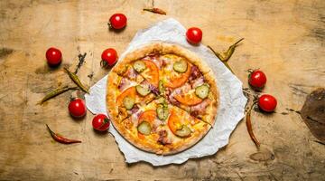 Tasty pizza with bacon and tomatoes. On wooden table. photo