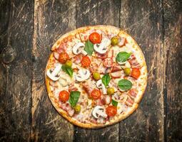 Fresh homemade pizza. On wooden background photo