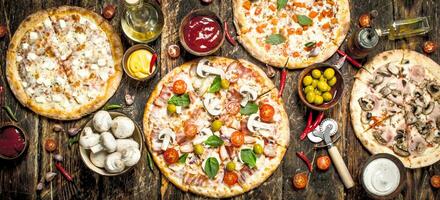 variety of pizzas. On wooden background photo