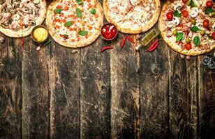 variety of pizzas. On wooden background photo