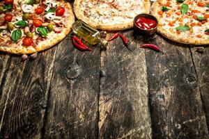 variety of pizzas. On wooden background photo