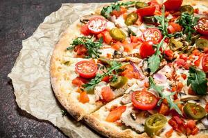 fresh pizza with tomatoes and greens. photo