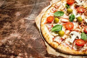 Fresh pizza with meat and tomatoes. photo