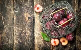 Fresh plums in a mesh bag. photo
