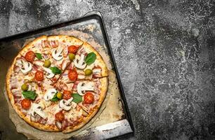 Fresh pizza on a baking sheet. photo