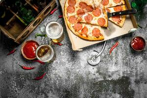 Pizza background. Pepperoni with beer. photo