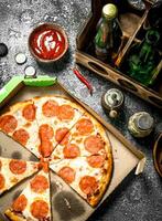 Pizza background. Pepperoni with beer. photo