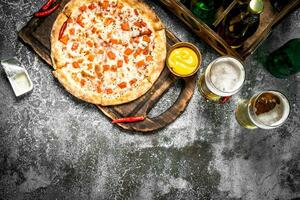 Pizza margarita with sauce and fresh beer. photo